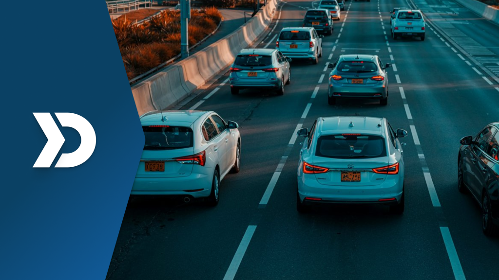 Multiple vehicles driving on a multi-lane highway during golden hour, symbolizing the use of mobile telematics in detecting insurance fraud through real-time driving data.