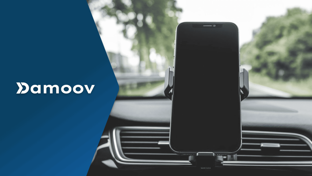 Smartphone mounted on car dashboard using Damoov’s mobile telematics for safe driving and real-time trip tracking